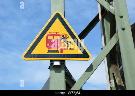 "No a scavalcare la linea rossa' giallo di avvertimento triangolare signn in tedesco stazione ferroviaria mostra stilizzata persona che cade dalla piattaforma Foto Stock