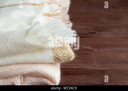 Caldo e morbido piegato plaid di lana su sfondo di legno Foto Stock