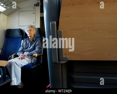 Un elegante signora anziana travelin sul treno nella città di Lussemburgo. Foto Stock