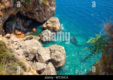 Vista superiore della roccia e mare blu dell'acqua. Nella roccia vi è una grande caverna che è allagato con acqua di mare Foto Stock