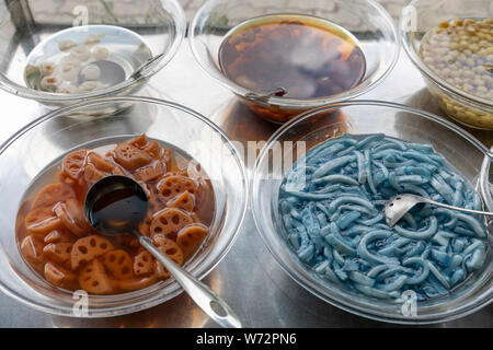 Gli ingredienti utilizzati in vietnamita Street alimenti disposti su un carrello per in acciaio inox Foto Stock