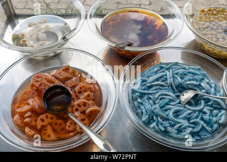 Gli ingredienti utilizzati in vietnamita Street alimenti disposti su un carrello per in acciaio inox Foto Stock