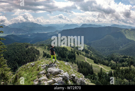 All'aperto panorama di escursionista in piedi nella verde campagna con foggy valley in estate Foto Stock