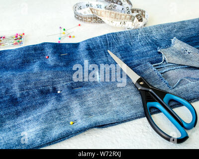 Fai Un Buco Nei Jeans Blu Con Le Forbici Foto Stock Alamy