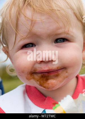 Bambino con la faccia sporca dopo aver mangiato cioccolato, REGNO UNITO Foto Stock