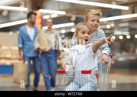 Ritratto di due entusiasti di equitazione per bambini carrello nel supermercato, ritmo di copia Foto Stock
