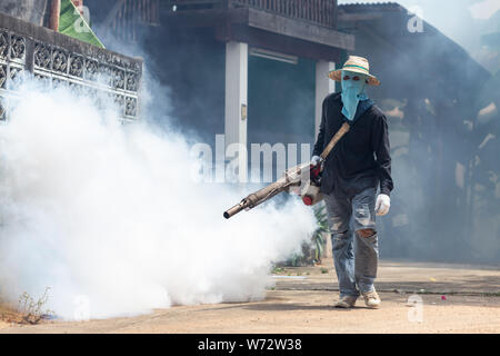 Un repellente per le zanzare concetto : un uomo di appannamento prodotto chimico per eliminare zanzara presso la strada Foto Stock