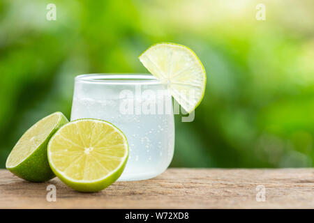 Close-up di vetro ghiacciato soda limone sul tavolo di legno con sfumatura verde spazio per il testo o per la progettazione Foto Stock