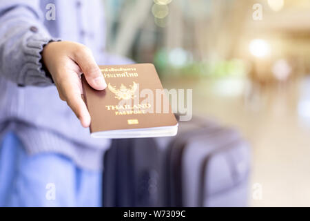 I viaggiatori che mostra il loro passaporto Thailandia presso l'aeroporto. Controllo passaporto mentre il concetto di viaggio. Focus sul passaporto Foto Stock