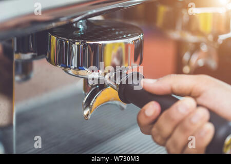 Mano del barista azienda caffè manomissione e di rendere la preparazione del caffè in servizio nel cafe concept Foto Stock