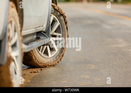 Ruota della vettura SUV con sporco da fango e argilla. Parcheggio sulla strada per la sicurezza del concetto di unità Foto Stock