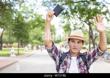 Asian per turisti in cerca e ricerca del proprietario del portafoglio nero che ha trovato in attrazione turistica. Perdere il concetto di portafoglio Foto Stock
