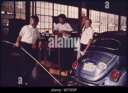 Giovane donna orologi di un analizzatore di gas di scarico la macchina come la sua auto è in fase di test presso un'emissione automatica stazione di ispezione nel centro cittadino di Cincinnati, Ohio. L'AUTO NON HA SUPERATO IL TEST PER IL MONOSSIDO DI CARBONIO E LE EMISSIONI DI IDROCARBURI E HA RICEVUTO UN ADESIVO TEMPORANEO. Tutti gli impieghi leggeri, accensione a scintilla POWERED VEICOLI A MOTORE DEVE PASSARE PER LA PROVA DI EMISSIONI ANNUALMENTE NONCHÉ UN CONTROLLO DI SICUREZZA CHE È STATA IN VIGORE DAL 1940. (Vedi foto n. 15472 attraverso 78) Foto Stock