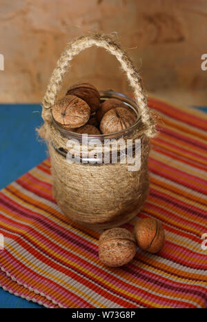 Le noci in una tabella in un vasetto di vetro Foto Stock