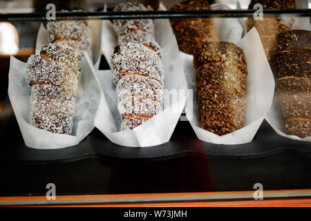 Trdelnik o Trdlo o Kurtosh Kalach essendo cotti sul contatore. Trdelnik è il cibo di strada di Praga. È considerato un tradizionale nazionale ceca dolce fo Foto Stock