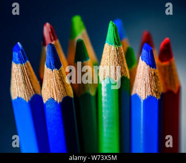 Primo piano delle colorate matite suggerimenti con sgranate texture di legno Foto Stock