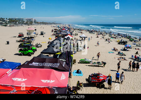 Huntington Beach, CA / STATI UNITI D'America - 7 Aprile 2019: Jet ski PWC gara. Gli astanti, il fornitore e gli sciatori a getto sulla spiaggia. Oceano e dello skyline della citta'. Foto Stock