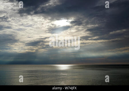 Cielo di tramonto sul mare. La luce del sole rende il suo modo attraverso le nuvole e il sole splende sopra la superficie dell'acqua. Lago di Michig Foto Stock