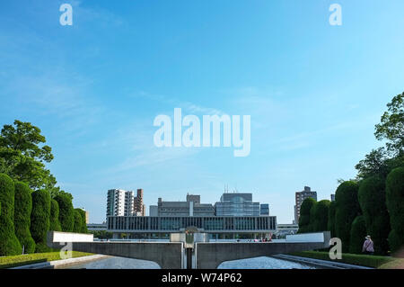 La pace di fiamma con il Museo Memoriale della Pace in background, nel Parco del Memoriale della Pace di Hiroshima, Giappone. Foto Stock