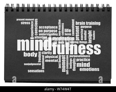 Mindfulness word cloud - testo bianco in un isolato di carta nera sketchbook Foto Stock