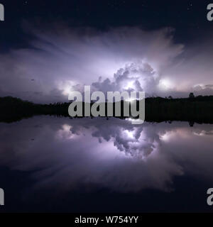 Un thunderhead è riflessa in un lago in Everglades National Park durante un notturno di tempesta elettrica Foto Stock