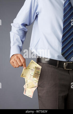 Uomo d'affari con banconote in tasca Foto Stock