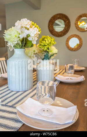 Posateria e fiori su un marrone tavolo da pranzo in legno con tavolo guide di scorrimento Foto Stock