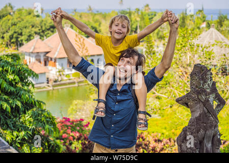 Papà e figlio in acqua Palace Soekasada Taman Ujung rovine sulla isola di Bali in Indonesia. Incredibile architettura antica. Viaggi e vacanze sfondo Foto Stock