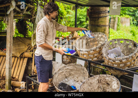 L'uomo separatamente preleva il cestino. Separare la garbage collection concept Foto Stock