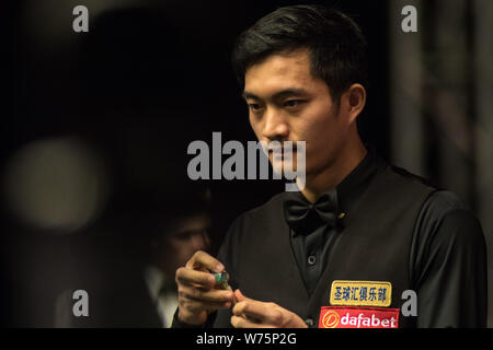 Fang Xiongman della Cina i gessi spunto come egli ritiene che un colpo di Marco fu di Hong Kong nella loro seconda partita durante il 2017 Dafabet Scottish ope Foto Stock