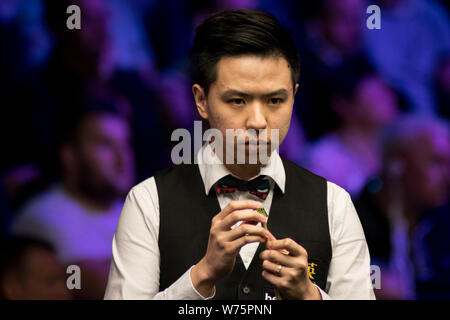 Xiao Guodong della Cina i gessi spunto come egli ritiene che un colpo di Martin Gould di Inghilterra nel loro quarto round corrispondere durante il 2017 uk Betway Champions Foto Stock