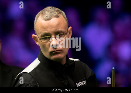 Martin Gould di Inghilterra ritiene che un colpo di Xiao Guodong della Cina nel loro quarto round corrispondere durante il 2017 Betway UK Championship Snooker tournamen Foto Stock