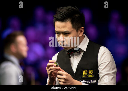 Xiao Guodong della Cina i gessi spunto come egli ritiene che un colpo di Martin Gould di Inghilterra nel loro quarto round corrispondere durante il 2017 uk Betway Champions Foto Stock