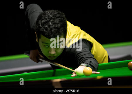 Li appendere della Cina gioca un colpo a Scott Donaldson della Scozia nel loro 1/16 partita finale durante il 2017 Betway UK Championship Snooker nel torneo di Yo Foto Stock