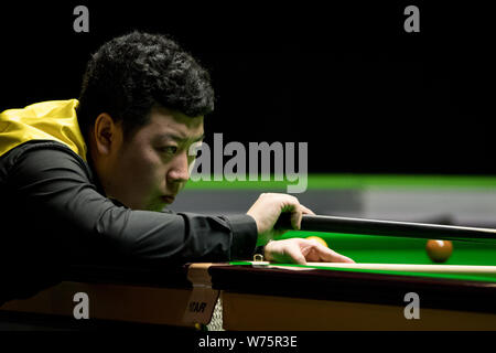 Li appendere della Cina gioca un colpo a Scott Donaldson della Scozia nel loro 1/16 partita finale durante il 2017 Betway UK Championship Snooker nel torneo di Yo Foto Stock