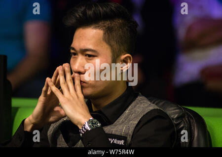 Cao Yupeng della Cina reagisce come egli orologi John Higgins della Scozia a giocare un colpo nella loro seconda partita durante il 2017 Betway campionato britannico sn Foto Stock