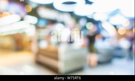 Sfocare lo sfondo del cliente shopping al supermercato store la sfocatura dello sfondo con luci bokeh di fondo.client pagare roba di generi alimentari al cassiere contatore in store Foto Stock