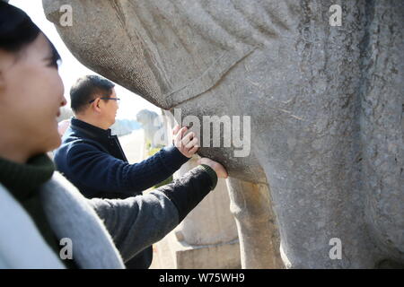 --FILE--turisti corsa lo stomaco della statua equestre di pregare per il buon appetito presso le Tombe dei Ming, una raccolta di mausolei costruito dagli imperatori Foto Stock