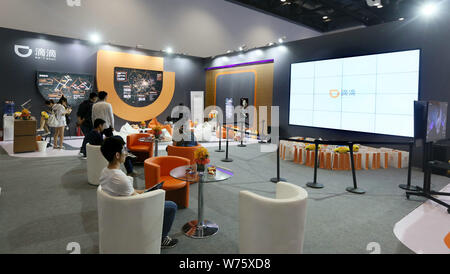 --FILE -- la gente visita lo stand del taxi-salutando e auto-service app Didi Chuxing durante il 2017 Global Mobile Internet Conferenza di Pechino, mento Foto Stock