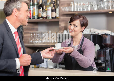 L'uomo riceve il caffè dalla cameriera Foto Stock