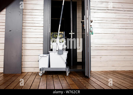 Portieri carrello tenendo la porta della camera aperta mentre vengono puliti. Hotel la pulizia. Spazio per il testo. Foto Stock