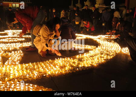 Per i fanatici del cinese luce di lampade a burro di pregare per la buona fortuna durante un festival del memoriale di Tsong Khapa della morte al Guangren Tempio Lama in Xi'an Foto Stock
