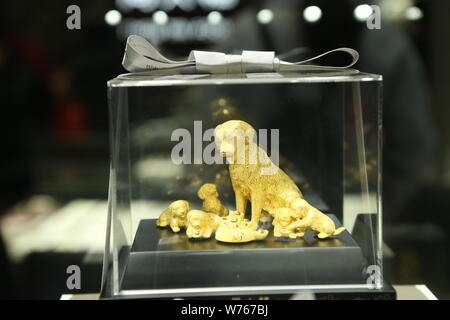 Un ornamento d'oro con cane è sul display in un negozio a Shanghai in Cina, 27 dicembre 2017. Secondo il calendario lunare cinese, 2018 è sì Foto Stock