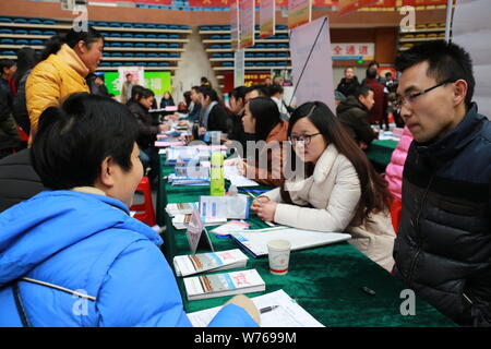 --FILE--Cinese in cerca di lavoro parla con intervistatori in cerca di occupazione a una fiera del lavoro in città Chizhou, est cinese della provincia di Anhui, 9 dicembre 2017. Foto Stock