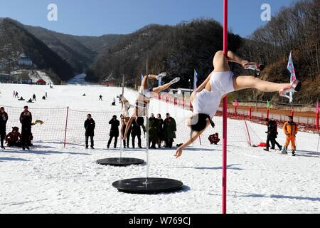 Ragazze cinesi indossando bikini eseguire pole dance contro il freddo in un parco di sci in Luanchuan county, Luoyang city, centrale cinese della provincia di Henan, 3 Decem Foto Stock