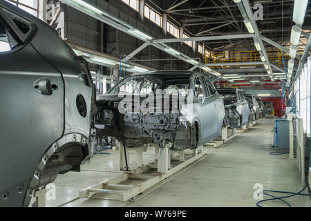 Il trasportatore è costituito da corpi di vetture. Macchine di assemblaggio in fabbrica della macchina Foto Stock