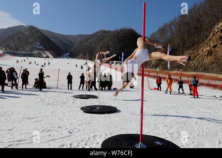 Ragazze cinesi indossando bikini eseguire pole dance contro il freddo in un parco di sci in Luanchuan county, Luoyang city, centrale cinese della provincia di Henan, 3 Decem Foto Stock