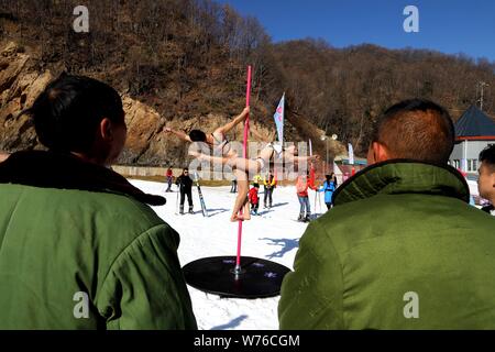 Ragazze cinesi indossando bikini eseguire pole dance contro il freddo in un parco di sci in Luanchuan county, Luoyang city, centrale cinese della provincia di Henan, 3 Decem Foto Stock