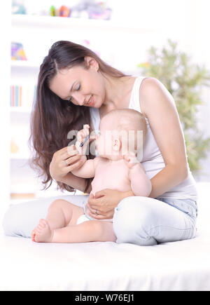 Giovane madre insegna al bambino stand. Il concetto di maternità Foto Stock