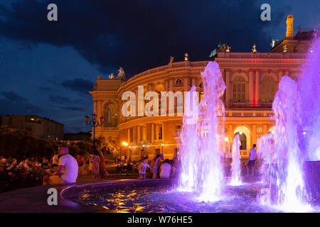 Ucraina Odessa, 11 giugno 2019. Vista laterale del national academic opera edificio e illuminate fontana al tramonto Foto Stock